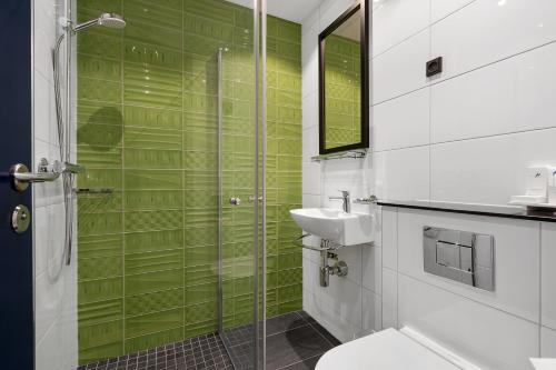 
a bathroom with a shower, sink, and toilet at ProfilHotels Richmond in Copenhagen
