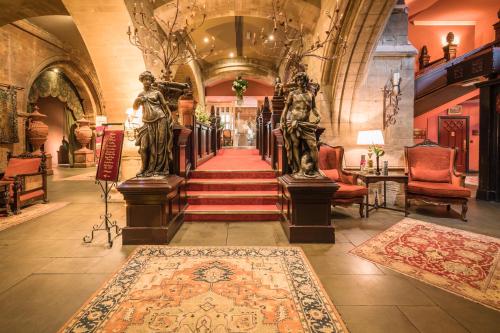 a hallway with statues and a staircase in a building at Coombe Abbey Hotel in Coventry