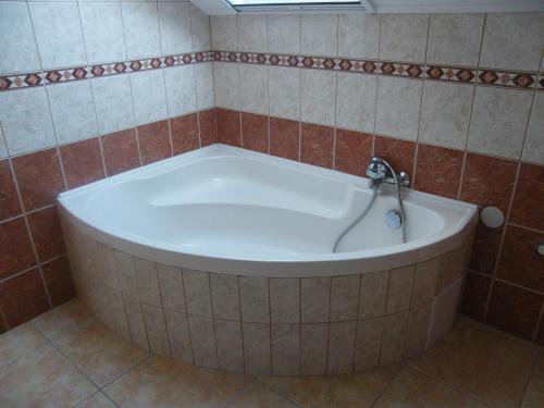 a bath tub with a faucet in a bathroom at Beach Resident in Balatonszemes