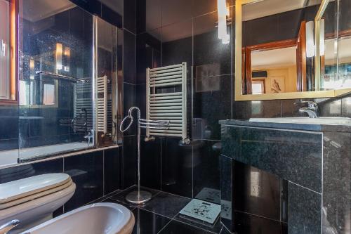 a bathroom with a toilet and a sink and a mirror at Costa Nova Ria View Apartment by Home Sweet Home Aveiro in Costa Nova