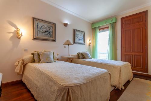 sypialnia z 2 łóżkami i oknem w obiekcie Costa Nova Ria View Apartment by Home Sweet Home Aveiro w mieście Costa Nova