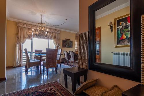 a dining room with a table and a mirror at Costa Nova Ria View Apartment by Home Sweet Home Aveiro in Costa Nova