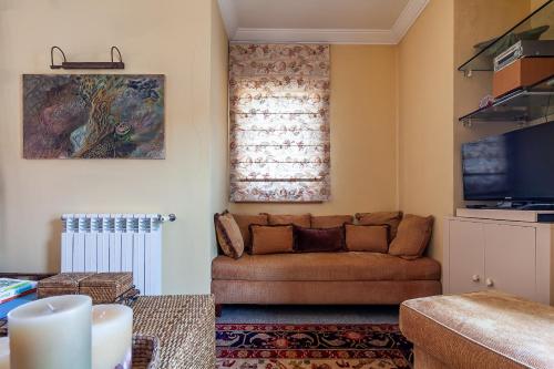 a living room with a couch and a television at Costa Nova Ria View Apartment by Home Sweet Home Aveiro in Costa Nova