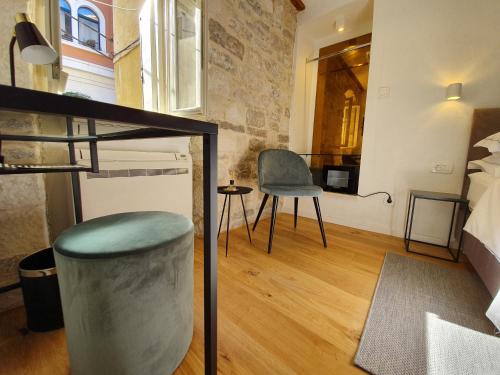 斯普利特的住宿－THE SUITES at central Split，一间卧室,卧室内配有一张床和一把椅子