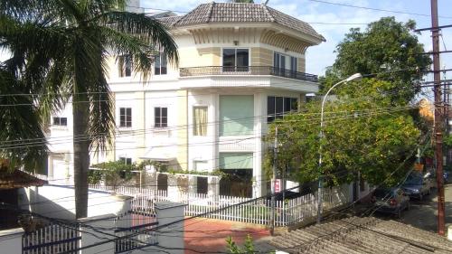 une maison blanche avec une clôture devant elle dans l'établissement Daffodils Spice Court, à Cochin