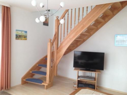 een woonkamer met een trap en een flatscreen-tv bij Ferienwohnung Kremer in Cuxhaven