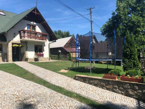 a house with a playground in the yard at Pokoje U Moniki in Grywałd