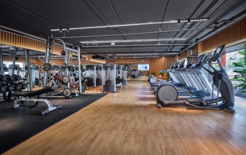 a gym with treadmills and elliptical machines at Fraser Suites Hanoi in Hanoi