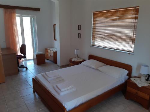 Un dormitorio con una cama con sábanas blancas y una ventana. en Swan House Panoramic View - Near the sea, en Zipárion