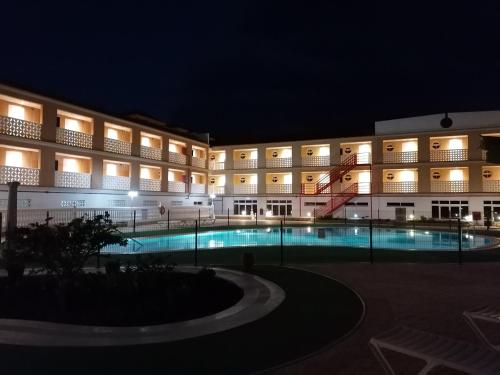un gran edificio con piscina por la noche en Apartamentos Parque Carolina, en Costa del Silencio