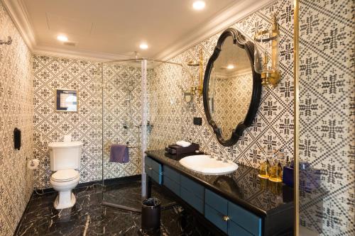 a bathroom with a toilet and a sink and a mirror at Silk Path Grand Sapa Resort & Spa in Sa Pa