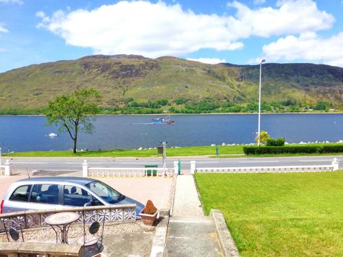 un'auto parcheggiata in un parcheggio vicino a un lago di The Willows - Room Only Accommodation a Fort William