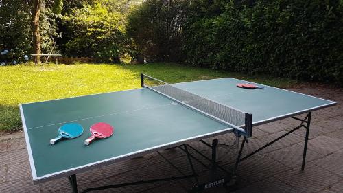 a ping pong table with two tennis rackets on it at B&B Villa Tavallini in Pollone
