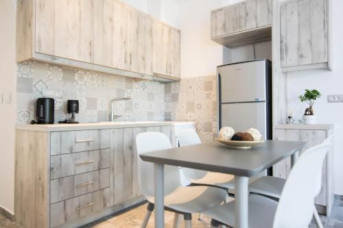 a kitchen with a table and chairs and a refrigerator at Santorini Villatzio Suites in Mesaria