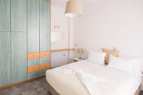 a bedroom with a large white bed and a cabinet at Santorini Villatzio Suites in Mesaria