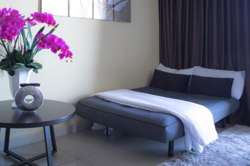 a bedroom with a bed and a table with purple flowers at Sky D'Mont Suites in Genting Highlands