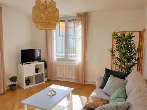 a living room with a couch and a table at Au 36, Les Apparts Hotel Joigny in Joigny