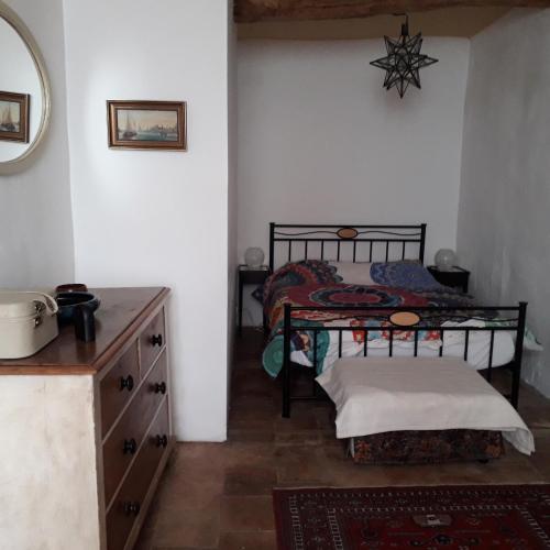 une chambre avec un lit et une commode dans l'établissement Maison Flamingo, à Saint-Geniès-de-Fontedit