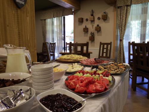 a table with many plates of food on it at Casa din Vale in Săcuieu