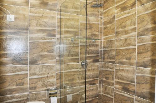 y baño con ducha y pared de madera. en MEDELEAN HOTEL, en Komrat