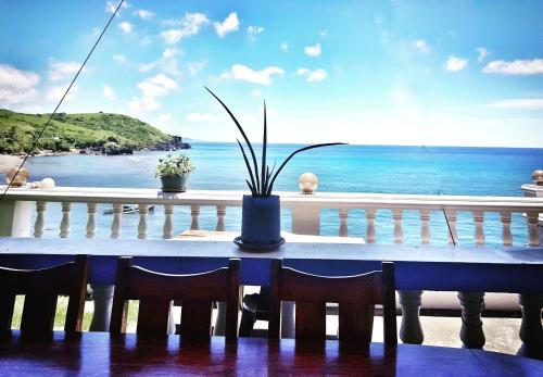 a table with chairs and a view of the ocean at shanedel's inn & café in Basco