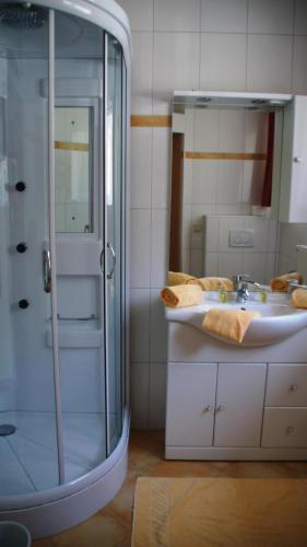 ein Bad mit einer Glasdusche und einem Waschbecken in der Unterkunft Mountain Motel in Kaprun