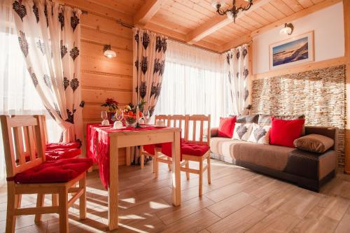 a living room with a table and a couch at Domki Pod Jemiołą in Zakopane