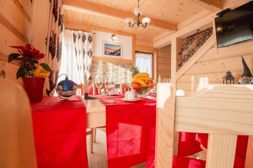 a room with two red tables with wine glasses at Domki Pod Jemiołą in Zakopane