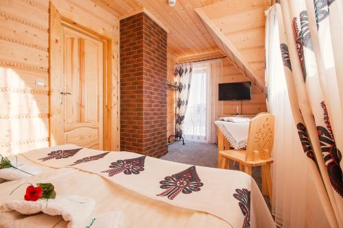 a bedroom with two beds in a wooden house at Domki Pod Jemiołą in Zakopane