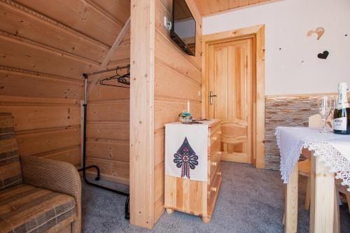 a room with a table in a wooden cabin at Domki Pod Jemiołą in Zakopane