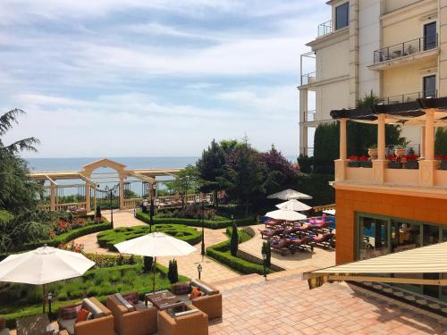 a hotel with tables and umbrellas in a courtyard at La Gioconda Boutique Hotel in Odesa