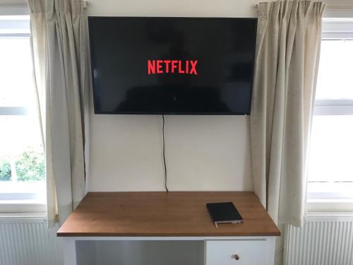 a flat screen tv on a wall in a room at Moorhouse Farm Flat in Telford