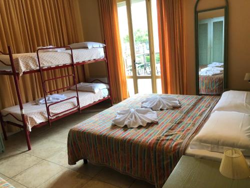 a bedroom with two bunk beds and a window at Hotel AMALFI in Lido di Jesolo