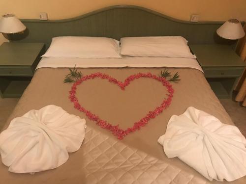 a bed with a heart on it with two towels at Hotel AMALFI in Lido di Jesolo