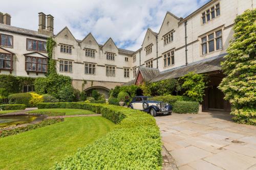 an old car parked in the courtyard of a building at Coombe Abbey Hotel in Coventry