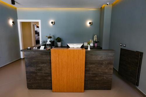 a bar with a wooden counter in a room at Home Hotel in Tirana