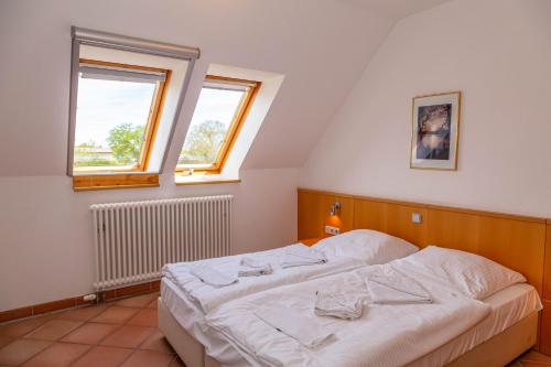 a bedroom with a white bed with two windows at Ferienwohnung Traumurlaub in Dewichow