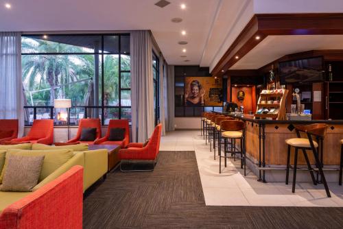 aha Kopanong Hotel & Conference Centre في Bredell: بار في مطعم ذو اثاث احمر واصفر