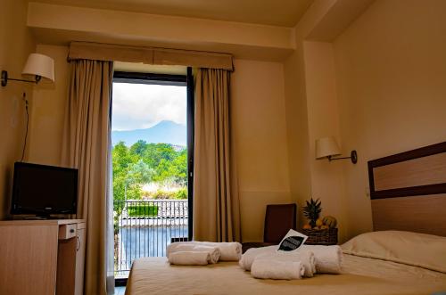 a bedroom with a large window with a view at Hotel Milomax in Milo