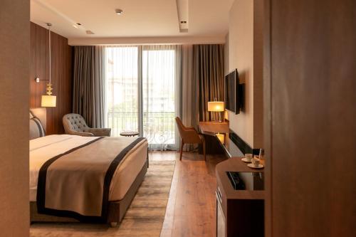 a hotel room with a bed and a large window at B&C HOTEL in Atakum