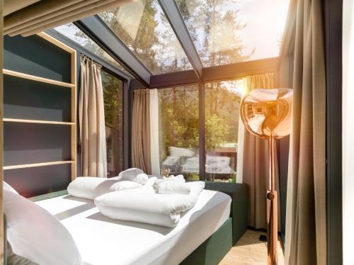 a room with two beds and a large window at Skyview Chalets am Camping Toblacher See in Dobbiaco