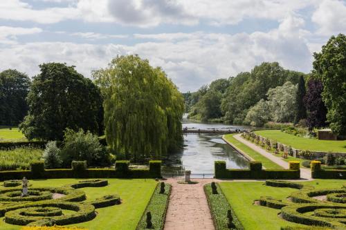 a view of a garden with a river and trees at Coombe Abbey Hotel in Coventry