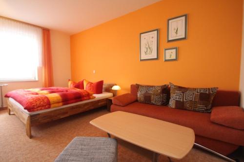 ein Wohnzimmer mit einem Bett und einem Sofa in der Unterkunft Gasthaus Forelle in Thale