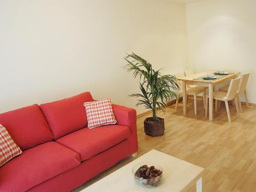 a living room with a red couch and a table at Aparthotel Nou Vielha in Vielha