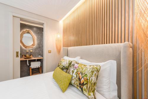 a bedroom with a bed with a pillow and a mirror at Victoria Project - Houses - Private Parking in Porto