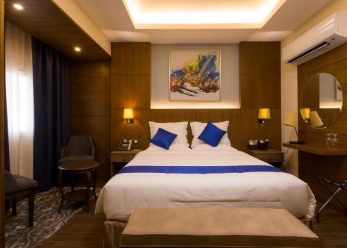 a hotel room with a large bed with blue pillows at Belad Bont Resort in Salalah