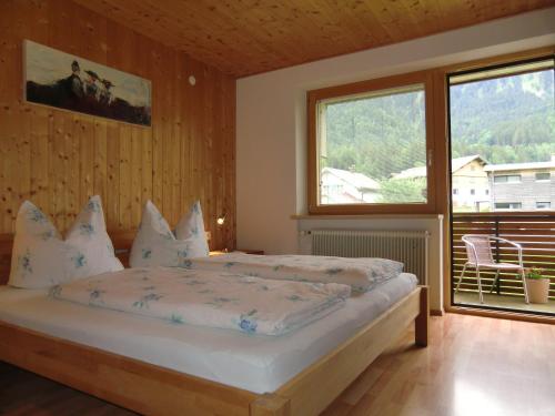 - une chambre avec un lit et une grande fenêtre dans l'établissement Ferienwohnung Annelies 379, à Mellau