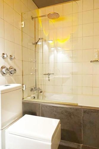 a bathroom with a shower and a toilet and a tub at Designerwohnung nahe Stuttgart Messe und Flughafen in Filderstadt