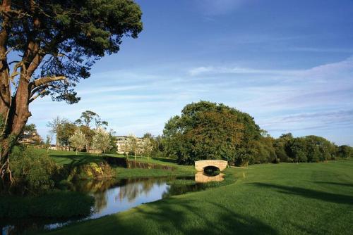 a bridge over a river in a golf course at Seafield Hotel & Spa Resort in Gorey