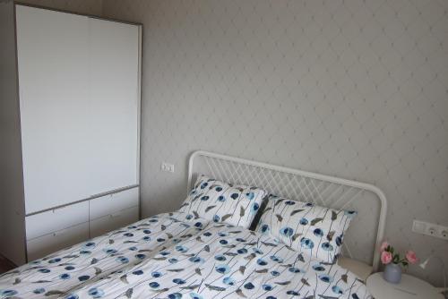 a white bed with blue and white sheets and pillows at Apartment Anna in Saldus